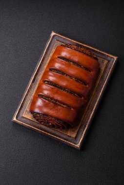 Koyu beton arka planda haşhaş tohumlu ev yapımı tatlı rulo.