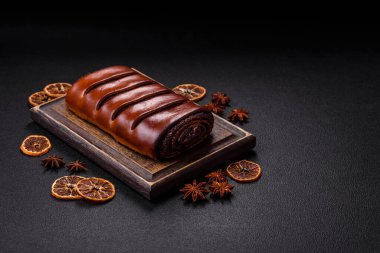 Koyu beton arka planda haşhaş tohumlu ev yapımı tatlı rulo.