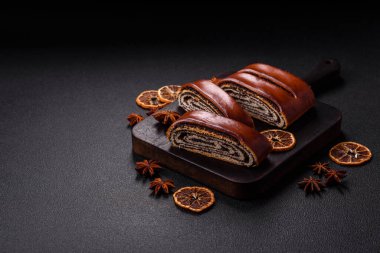 Koyu beton arka planda haşhaş tohumlu ev yapımı tatlı rulo.