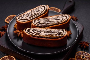 Koyu beton arka planda haşhaş tohumlu ev yapımı tatlı rulo.