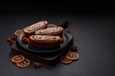 Koyu beton arka planda haşhaş tohumlu ev yapımı tatlı rulo.