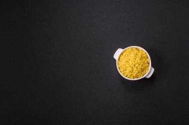 İtalyan arborio risotto pilavı. Tuz, baharat ve otlarla birlikte koyu beton bir arka planda.