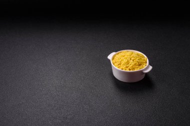 İtalyan arborio risotto pilavı. Tuz, baharat ve otlarla birlikte koyu beton bir arka planda.