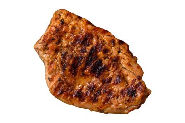 Izgarada pişirilmiş leziz domuz eti, beyaz bir arka planda tuz, baharat ve otlarla.