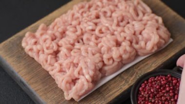 Koyu beton arka planda tuzlu, baharatlı ve otlu çiğ tavuk.