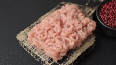 Koyu beton arka planda tuzlu, baharatlı ve otlu çiğ tavuk.