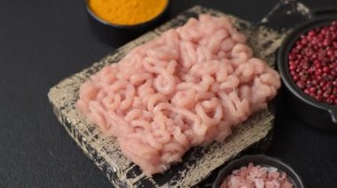 Koyu beton arka planda tuzlu, baharatlı ve otlu çiğ tavuk.