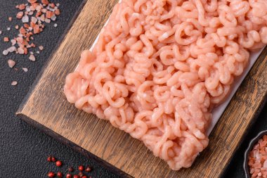 Koyu beton arka planda tuzlu, baharatlı ve otlu çiğ tavuk.