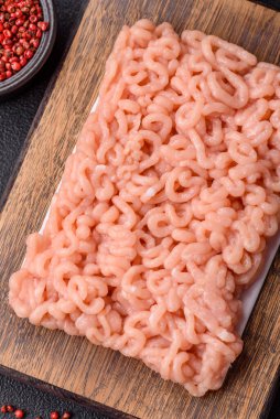 Koyu beton arka planda tuzlu, baharatlı ve otlu çiğ tavuk.