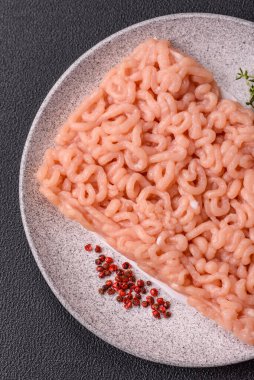 Koyu beton arka planda tuzlu, baharatlı ve otlu çiğ tavuk.