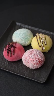 Lezzetli Asya mochi tatlısı pirinç hamuru kabuğu ve koyu beton arka planda meyveler.