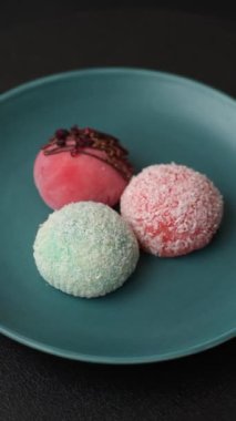Lezzetli Asya mochi tatlısı pirinç hamuru kabuğu ve koyu beton arka planda meyveler.