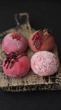 Lezzetli Asya mochi tatlısı pirinç hamuru kabuğu ve koyu beton arka planda meyveler.