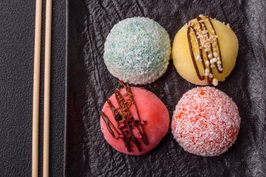 Lezzetli Asya mochi tatlısı pirinç hamuru kabuğu ve koyu beton arka planda meyveler.