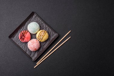 Lezzetli Asya mochi tatlısı pirinç hamuru kabuğu ve koyu beton arka planda meyveler.