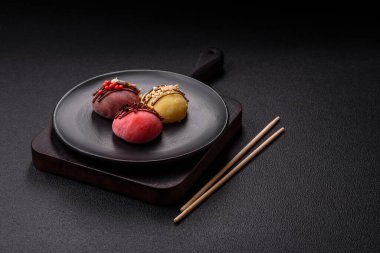 Lezzetli Asya mochi tatlısı pirinç hamuru kabuğu ve koyu beton arka planda meyveler.