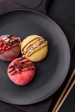 Lezzetli Asya mochi tatlısı pirinç hamuru kabuğu ve koyu beton arka planda meyveler.