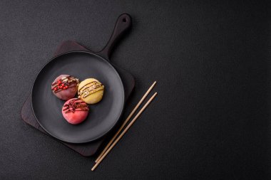 Lezzetli Asya mochi tatlısı pirinç hamuru kabuğu ve koyu beton arka planda meyveler.