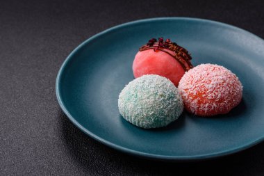 Lezzetli Asya mochi tatlısı pirinç hamuru kabuğu ve koyu beton arka planda meyveler.