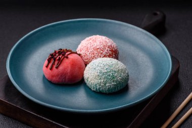 Lezzetli Asya mochi tatlısı pirinç hamuru kabuğu ve koyu beton arka planda meyveler.