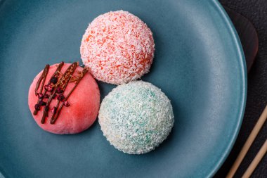 Lezzetli Asya mochi tatlısı pirinç hamuru kabuğu ve koyu beton arka planda meyveler.