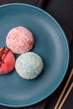 Lezzetli Asya mochi tatlısı pirinç hamuru kabuğu ve koyu beton arka planda meyveler.