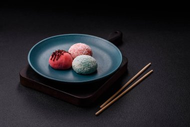 Lezzetli Asya mochi tatlısı pirinç hamuru kabuğu ve koyu beton arka planda meyveler.