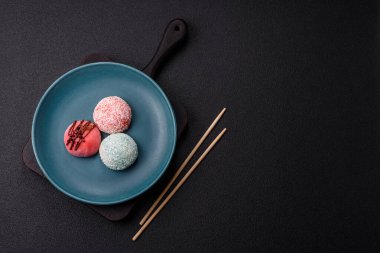 Lezzetli Asya mochi tatlısı pirinç hamuru kabuğu ve koyu beton arka planda meyveler.