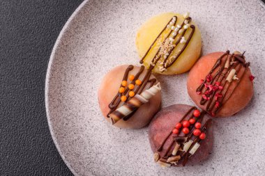 Lezzetli Asya mochi tatlısı pirinç hamuru kabuğu ve koyu beton arka planda meyveler.