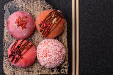 Lezzetli Asya mochi tatlısı pirinç hamuru kabuğu ve koyu beton arka planda meyveler.