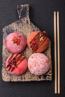 Lezzetli Asya mochi tatlısı pirinç hamuru kabuğu ve koyu beton arka planda meyveler.