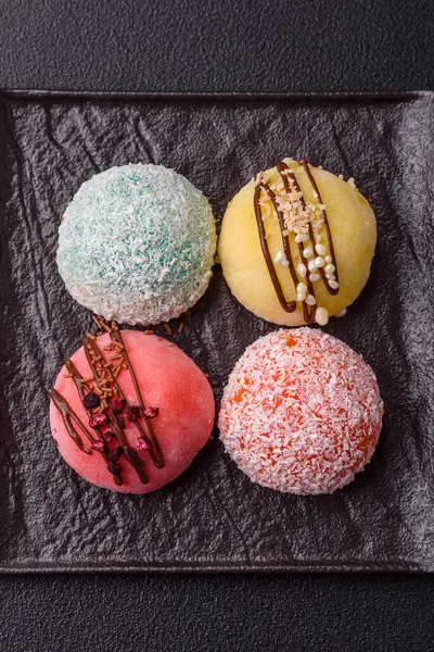 Lezzetli Asya mochi tatlısı pirinç hamuru kabuğu ve koyu beton arka planda meyveler.