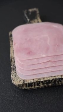 Kaynamış jambon, koyu beton arka planda körili ve baharatlı kare dilimlere bölünmüş.