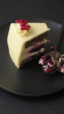 Koyu dokulu arka planda kiraz ve haşhaş tohumlu tatlı katmanlı peynirli kek.