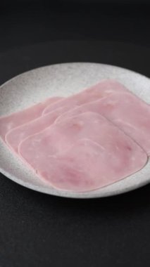 Kaynamış jambon, koyu beton arka planda körili ve baharatlı kare dilimlere bölünmüş.