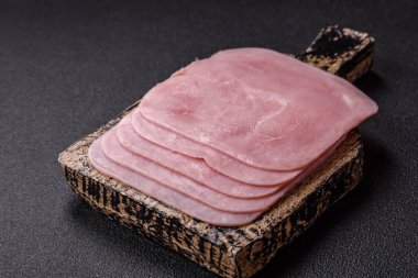 Kaynamış jambon, koyu beton arka planda körili ve baharatlı kare dilimlere bölünmüş.