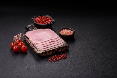 Kaynamış jambon, koyu beton arka planda körili ve baharatlı kare dilimlere bölünmüş.