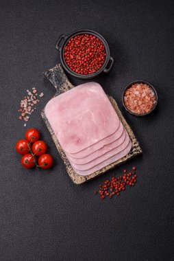 Kaynamış jambon, koyu beton arka planda körili ve baharatlı kare dilimlere bölünmüş.