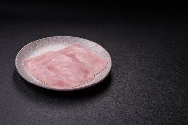 Kaynamış jambon, koyu beton arka planda körili ve baharatlı kare dilimlere bölünmüş.