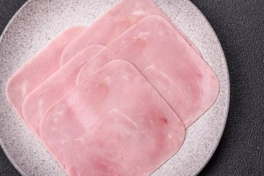 Kaynamış jambon, koyu beton arka planda körili ve baharatlı kare dilimlere bölünmüş.