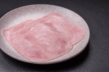 Kaynamış jambon, koyu beton arka planda körili ve baharatlı kare dilimlere bölünmüş.