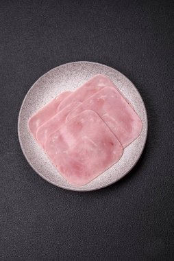 Kaynamış jambon, koyu beton arka planda körili ve baharatlı kare dilimlere bölünmüş.