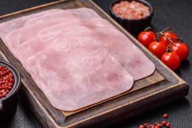 Kaynamış jambon, koyu beton arka planda körili ve baharatlı kare dilimlere bölünmüş.