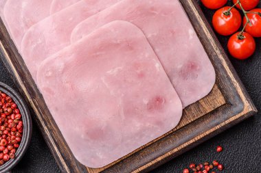 Kaynamış jambon, koyu beton arka planda körili ve baharatlı kare dilimlere bölünmüş.