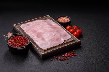 Kaynamış jambon, koyu beton arka planda körili ve baharatlı kare dilimlere bölünmüş.