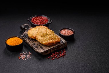 Lezzetli kızarmış domuz ya da koyu beton arka planda tuz ve baharatla ekilmiş tavuk pirzolası.