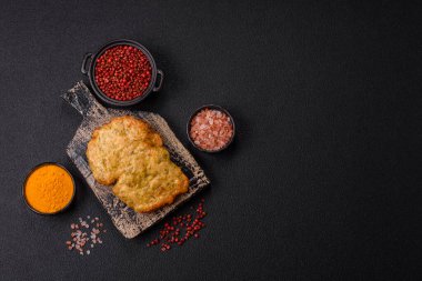 Lezzetli kızarmış domuz ya da koyu beton arka planda tuz ve baharatla ekilmiş tavuk pirzolası.