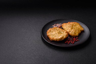 Lezzetli kızarmış domuz ya da koyu beton arka planda tuz ve baharatla ekilmiş tavuk pirzolası.