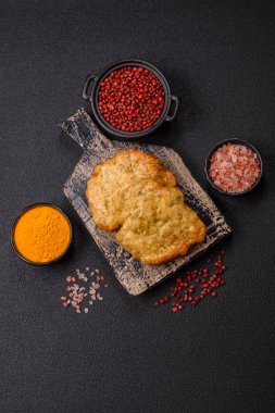 Lezzetli kızarmış domuz ya da koyu beton arka planda tuz ve baharatla ekilmiş tavuk pirzolası.