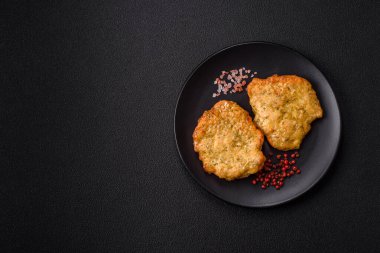 Lezzetli kızarmış domuz ya da koyu beton arka planda tuz ve baharatla ekilmiş tavuk pirzolası.